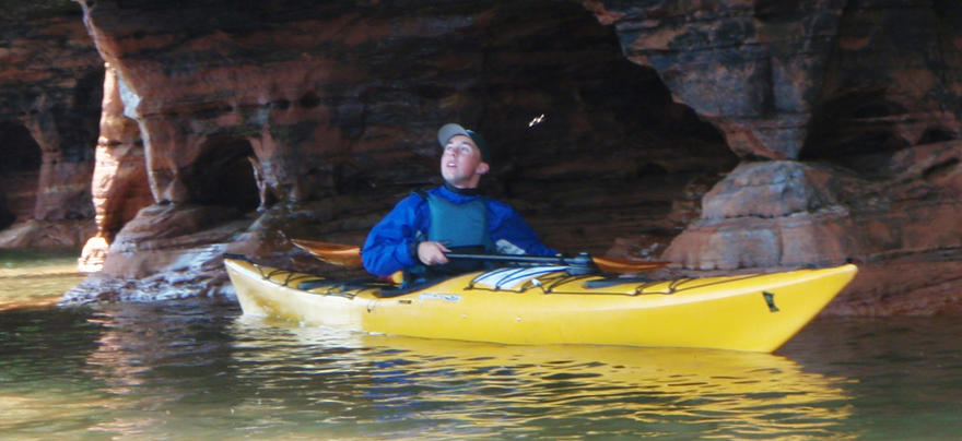 Man in a sea kayak in a cave
