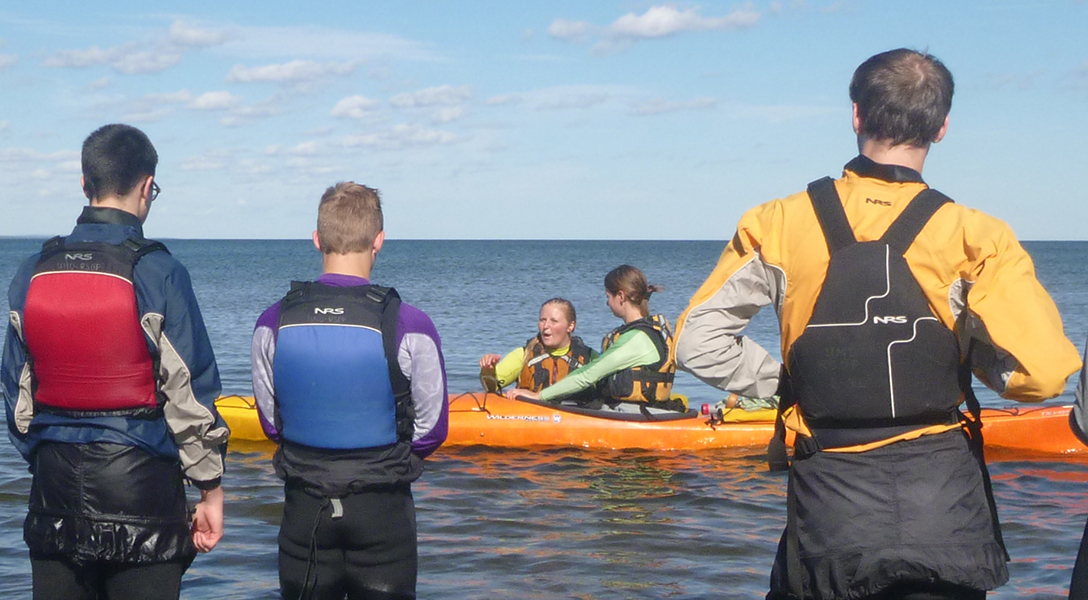 students watching a sea kayak skills demonstration in Lake Superior