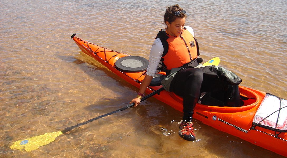 sea kayaker using the kickstand method to enter a sea kayak