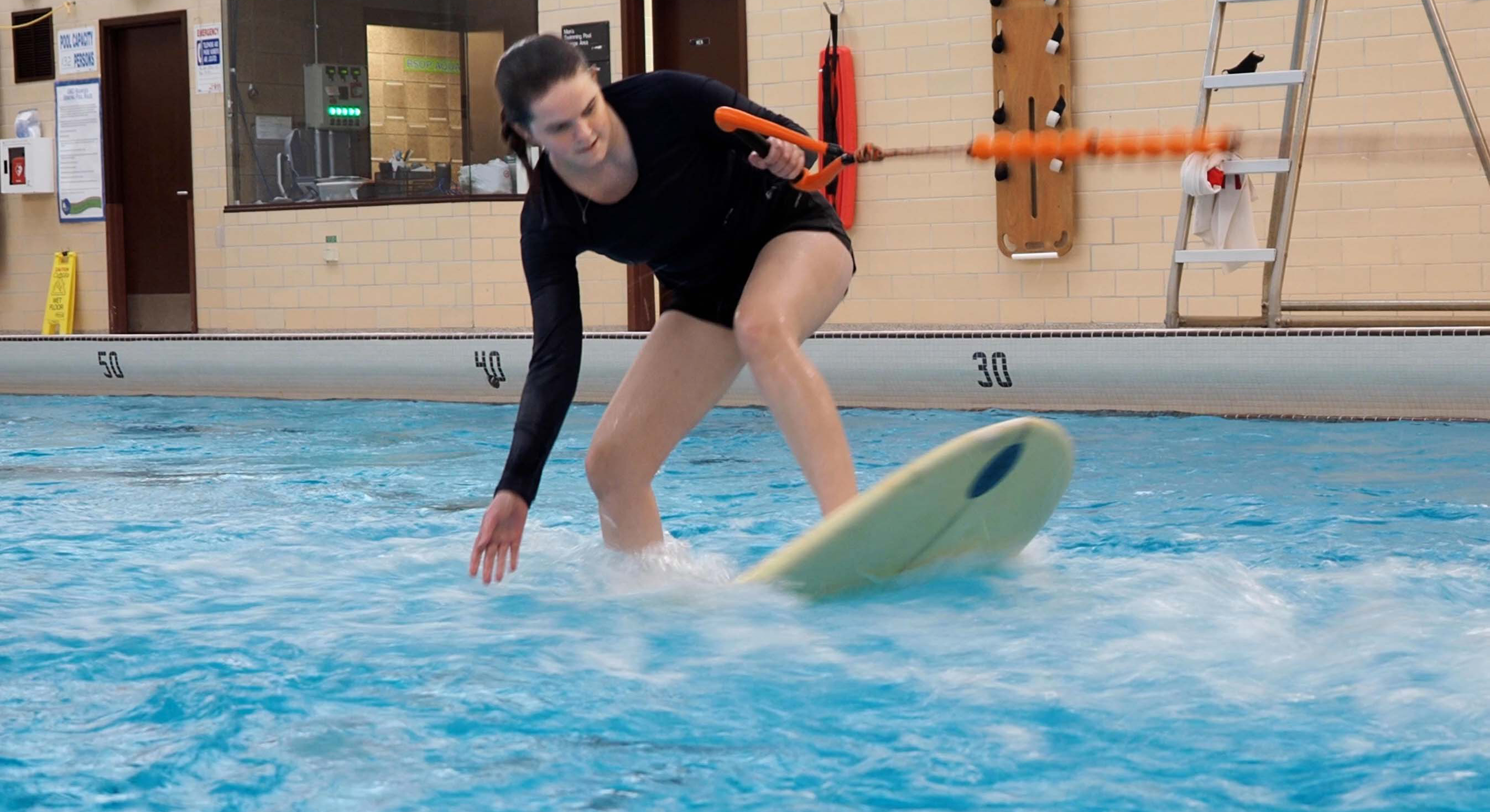 student surfing in the UMD pool