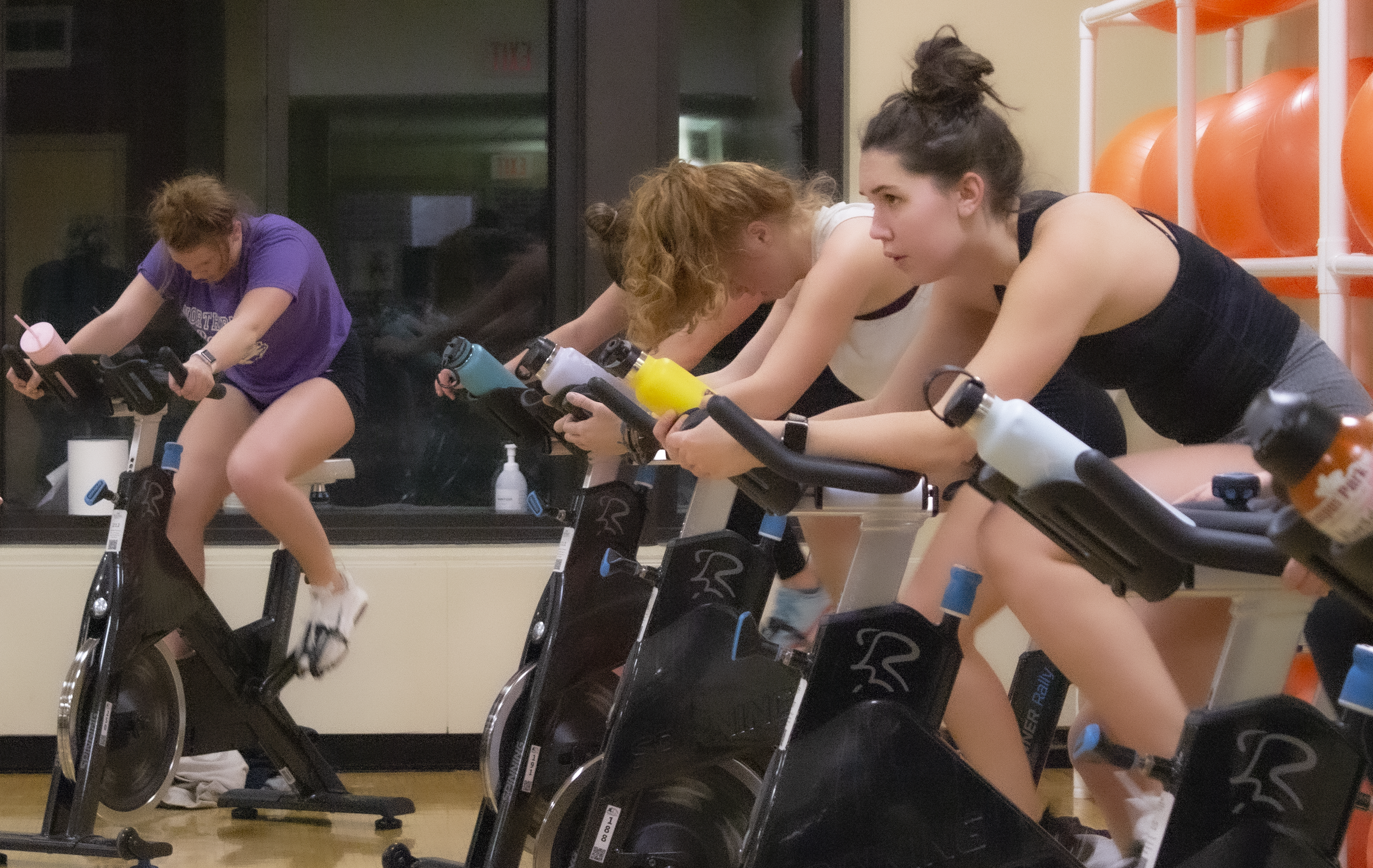 students in a spin class riding stationary bikes