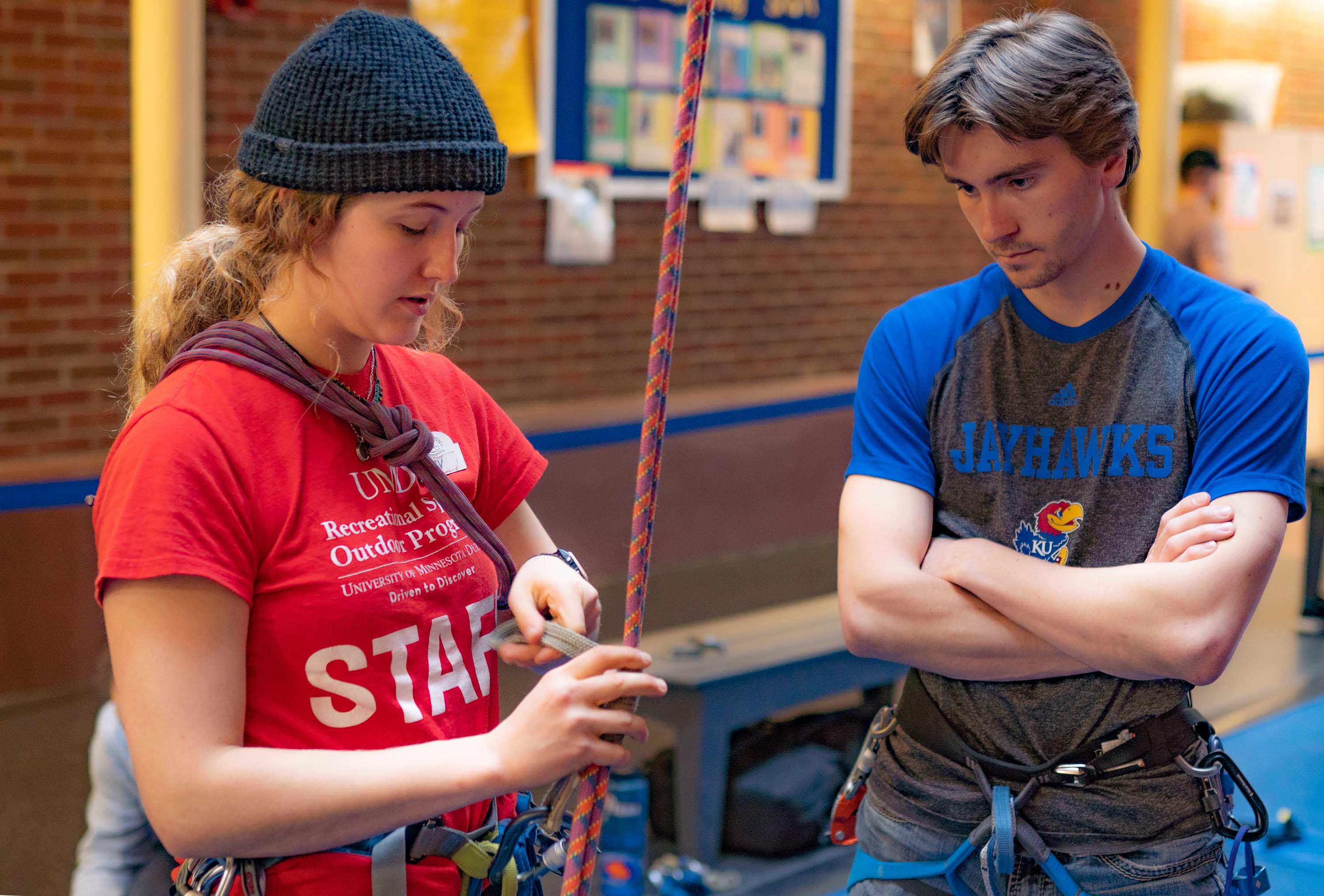 student teaching another student how to tie in before climbing