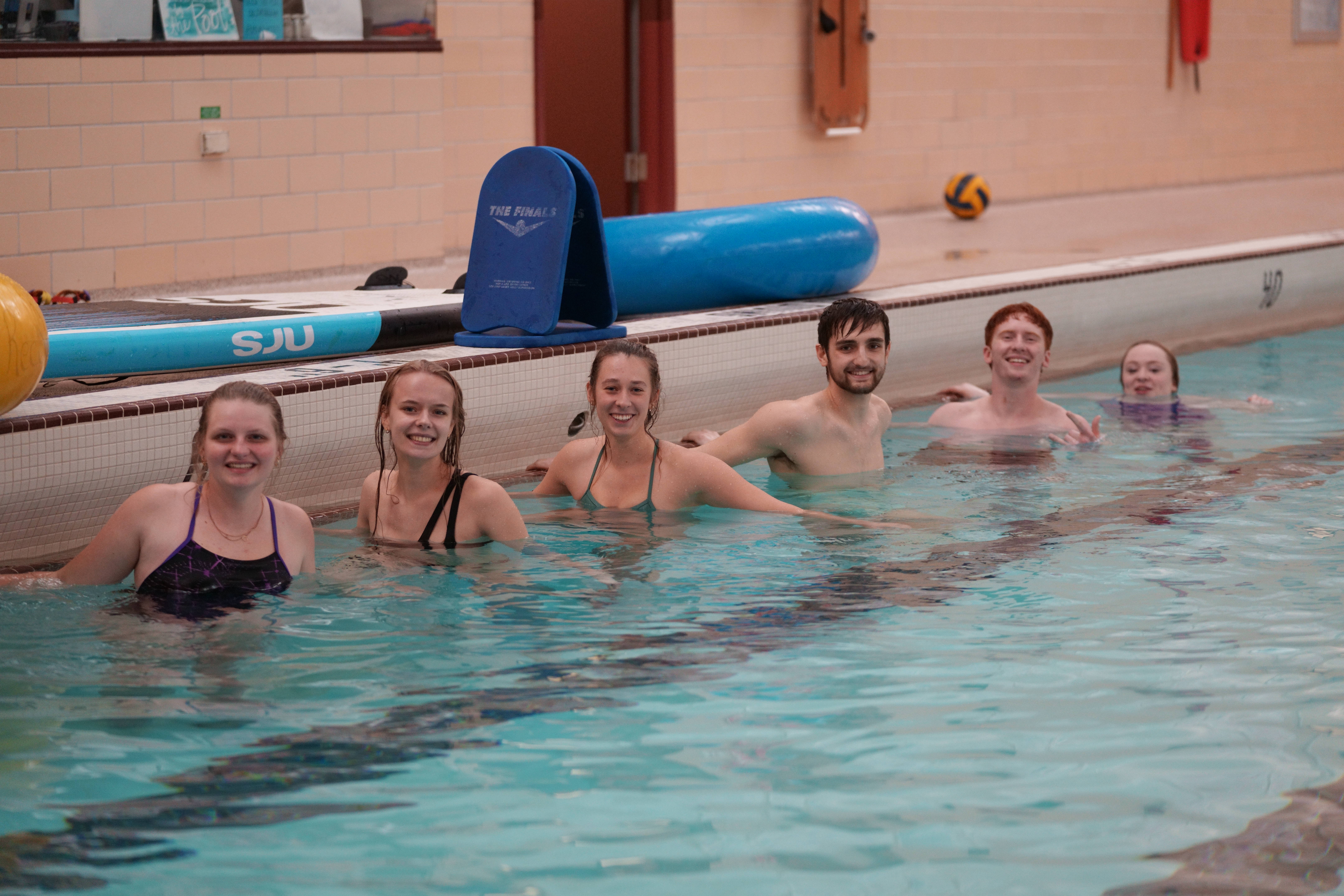 students posing in the swimming pool